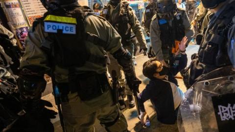 Hong Kong police officers arrest a protester, 15 December.