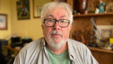 Tony Creedon stood in his flat in the Victoria Centre, looking at the camera for a photo.