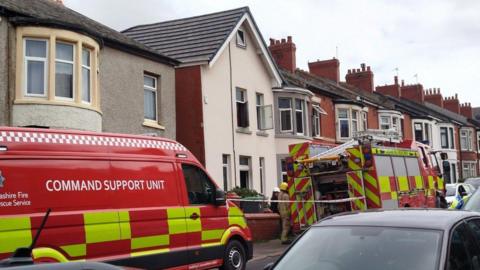 A fire engine and a fire van along with fire fighters outside a home on Redcar Road in Blackpool where a fire has broke out. The windows of the house are open and you can see fire damage.