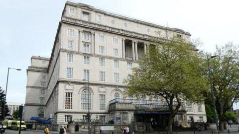 Exterior image of the Adelphi Hotel in Liverpool - it is white bricked with Georgian style windows and has two trees in front of it