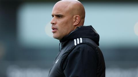 Marcus Bignot watches a game from the touchline