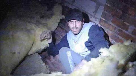 James Pedley hiding under loft insulation