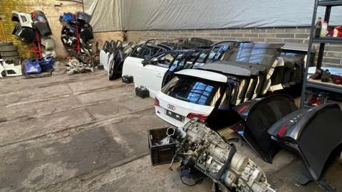 Car parts: back doors, side doors and bumpers in a warehouse building. Some of them are from Audis.