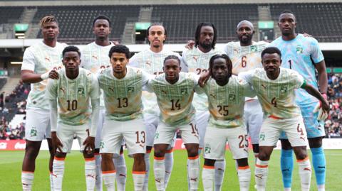 Ivory Coast team pose for photos before their friendly against South Korea
