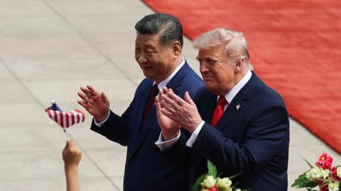 presidents Xi and Trump greeting crowd with flowers and a red carpet in the background