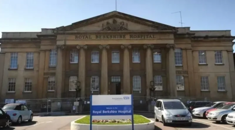 A general view of Royal Berkshire Hospital, with cars parked outside it.