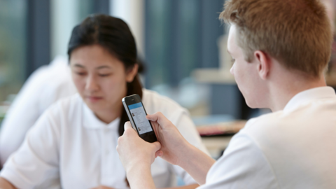 Schoolchildren holding mobile phone