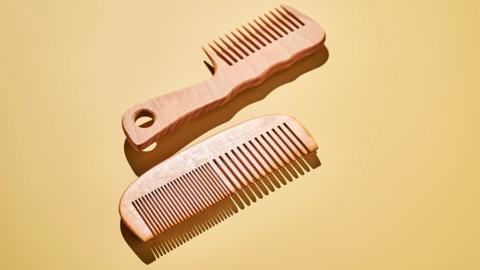 Two wooden combs on a yellow background