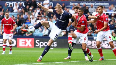 Millwall striker Josh Coburn controls the ball while surrounded by Wrexham players