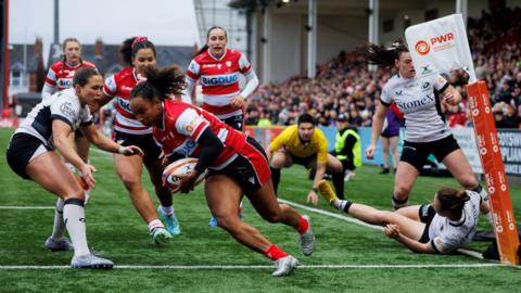 Jade Shekells (second left) runs over the tryline to score for Gloucester-Hartpury
