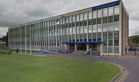 Guild House, a long rectangular three-storey building with blue Anglia Ruskin University sign at the top and a road and grass area at the front