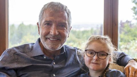 Graeme Souness and Isla Grist sitting side by side and posing for the camera