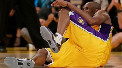 Kobe Bryant lies on the court in pain during a Los Angeles Lakers basketball game after he tore his Achilles