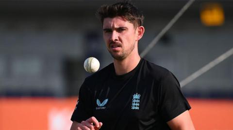 Josh Tongue throws himself a catch before bowling in a warm-up session for England