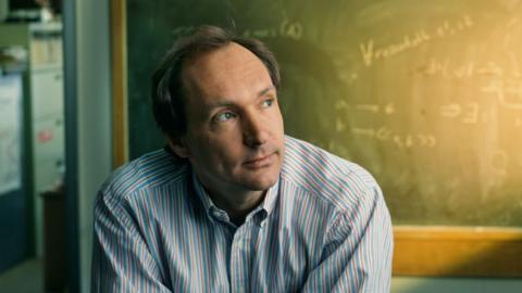 Sir Tim, looking younger in front of a chalkboard with mathematical equations written on it