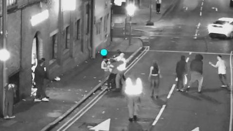 Blabck and white CCTV still showing a dozen or so people in the road in Talbot Street with some throwing punches in a scrum and others nearby