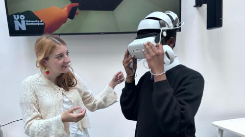 A woman guides a child in using a VR headset.