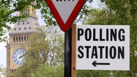 A polling station direction sign is attached to a street sign near the Elizabeth Tower, more commonly known as Big Ben, ahead of local elections, in London, Britain, May 1, 2024.