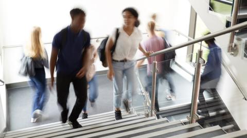 Blurred university students walking on stairs