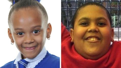 Elizabeth John is in the left image. She is wearing a white shift and blue jumper with a blue tie. She has earrings and her hair is tied back and she is smiling. and Ethan John. Ethan John is in the right image. He is wearing a red jumper and is looking up and smiling. He is outdoors and has a fence behind him.