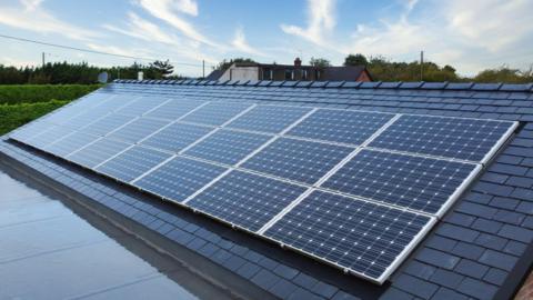 A set of 24 solar panels which have been fitted onto a roof at a home.