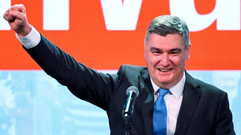  Zoran Milanovic wearing a suit and blue tie pumps his first after the first unofficial results of the second round of the presidential election