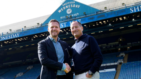 David Bruce is shaking hands with David Storch, in the Sheffield Wednesday stadium.