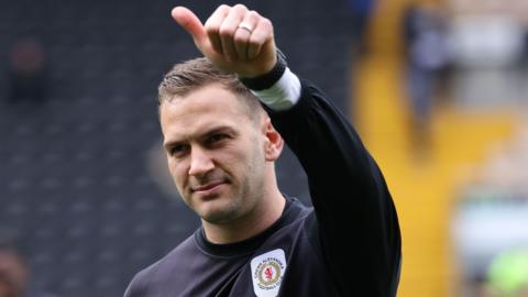 Crewe's Mickey Demetriou gives a thumbs up to the crowd during a pre-match warm-up
