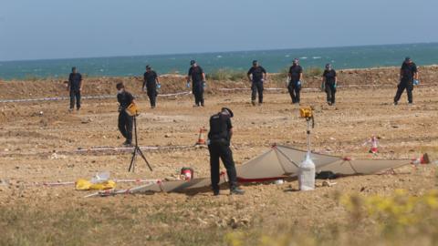 Officers walking along a sand dune just off the beach at Leysdown-on-Sea.