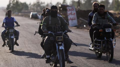 Armed Bedouin fighters ride motorbikes in southern Syria (17 July 2025)