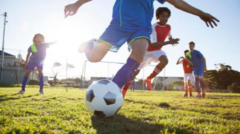 A stock image of boys playing football 