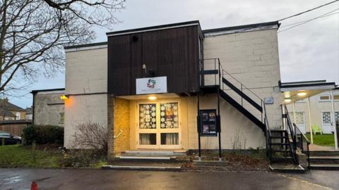 Outside the entrance of a community theatre venue.