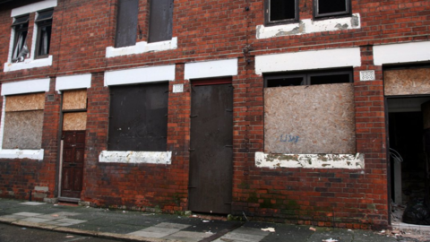 Boarded up red brick houses on a street