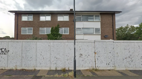 The empty police station, with a barrier surrounding it 