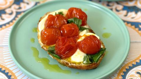 Tomato and mozzarella on top of toasted sourdough toast, drizzled with olive oil