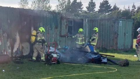 Firefighters tackling a blaze at some metal containers at Trimsaran rugby club.