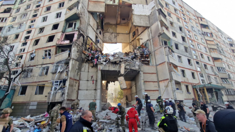 Firefighters and rescuers work at the site of an apartment building in Kharkiv hit by a Russian air strike on 24/9/24