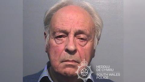 A mugshot of Anthony Pierce who has white hair and is wearing a striped blue shirt and blue sweatshirt and is looking directly at the camera with a neutral expression