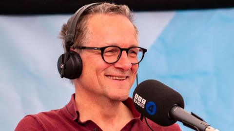 Michael Mosley wearing headphones during a radio recording at the Hay Festival