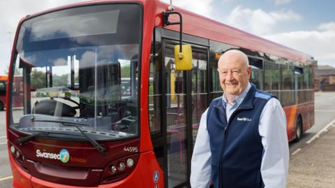 Kenny Beckers in front of a red bus