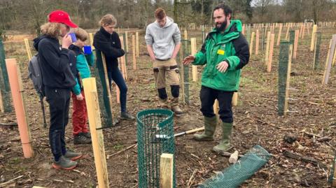 Volunteers planting trees in the Silk Wood area of the arboretum