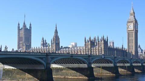 Westminster Bridge is pictured with a blue sky and the Houses of Parliament in the background