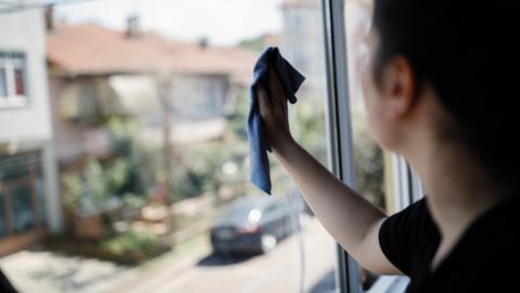 Young woman cleaning window