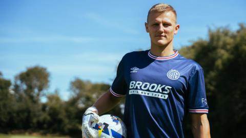  Jake Eastwood stands holding the ball in his right hand