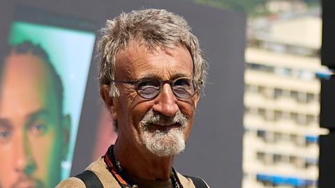 Eddie Jordan smiles while posing for a photograph