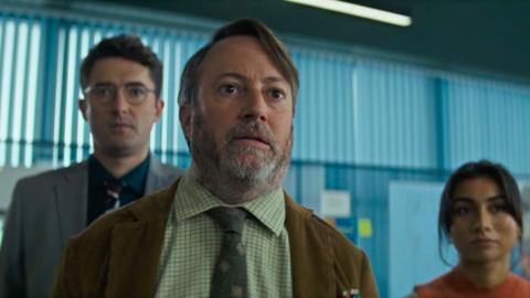 Three people in an office looking at something off camera.