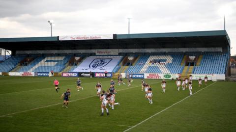 A men's rugby league match takes place at Featherstone Rovers' Millennium Stadium. The players are in action.