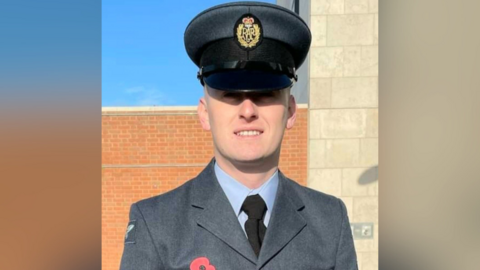 Senior Aircraftsman Shaun Thomas in his uniform, smiling at the camera