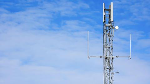 A mobile phone mast against blue sky.