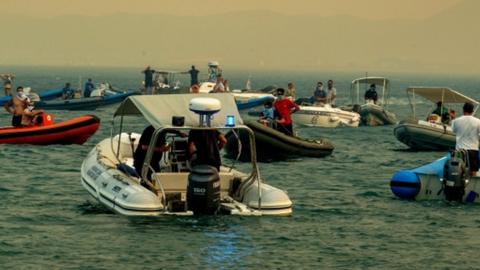 Boats waiting to evacuate people during a wildfire at Nea Anchialos